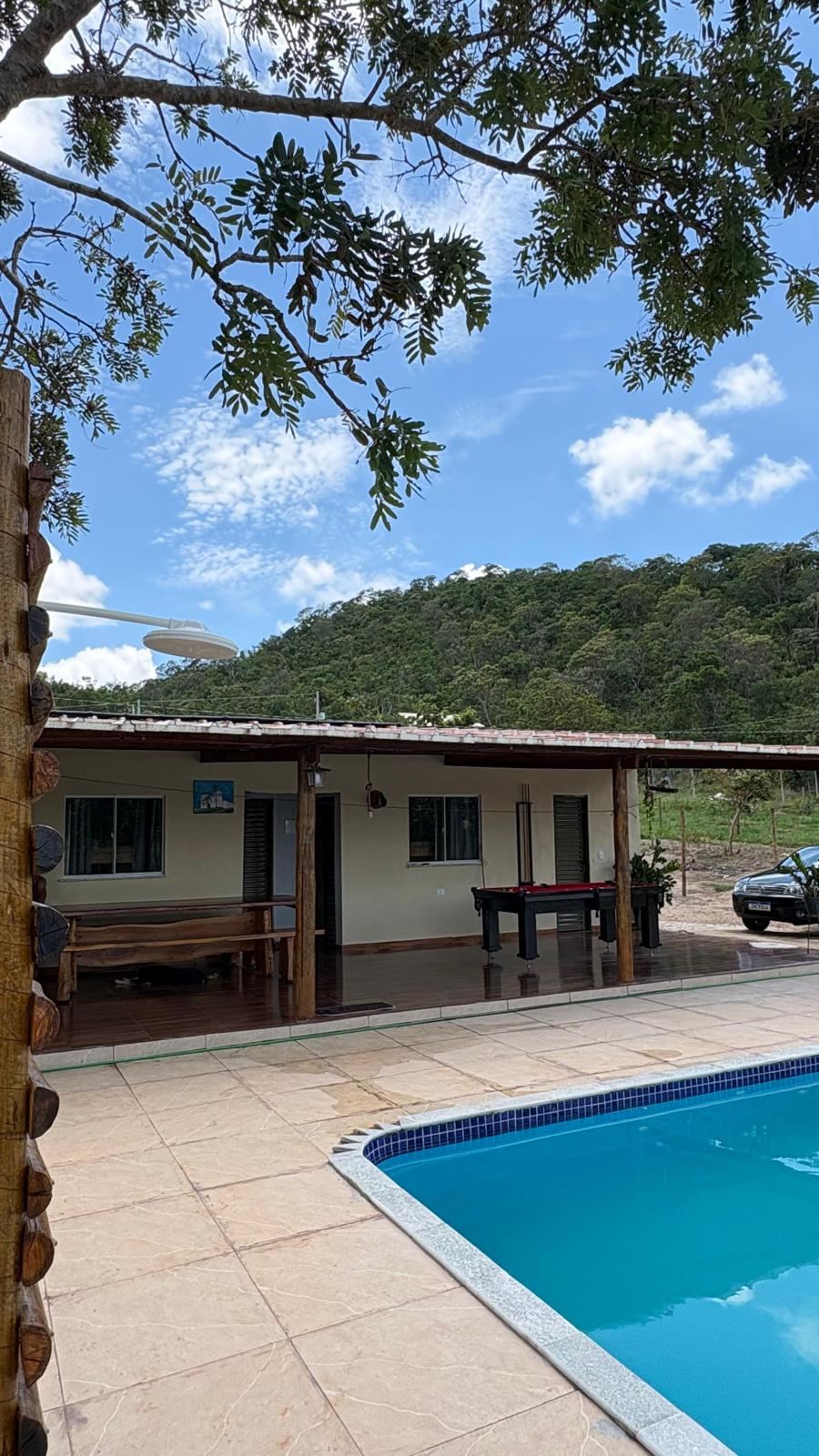 Área externa coberta da Chácara Refúgio das Araras com vista para a piscina e o Cerrado de Pirenópolis