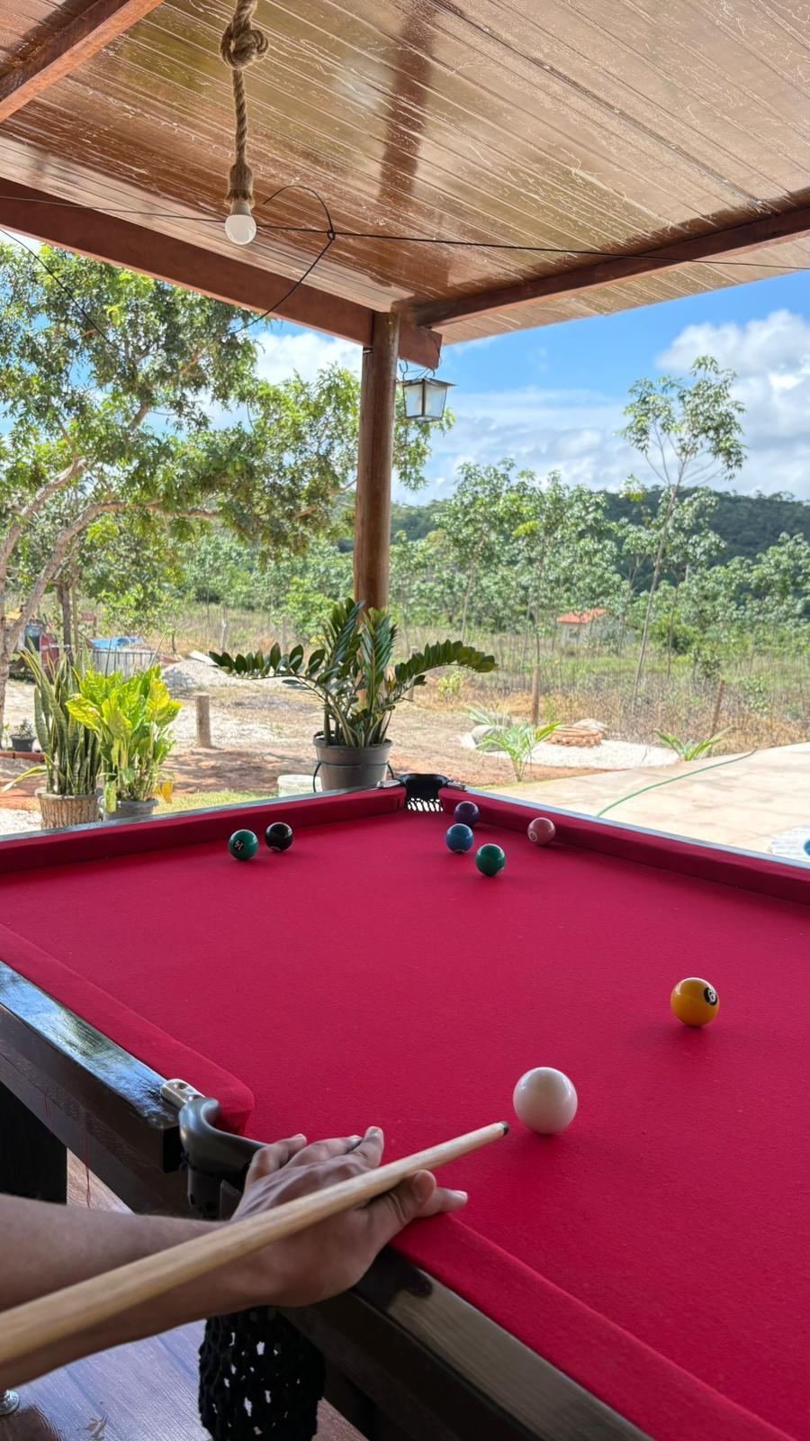 Amigos jogando sinuca na área coberta da chácara